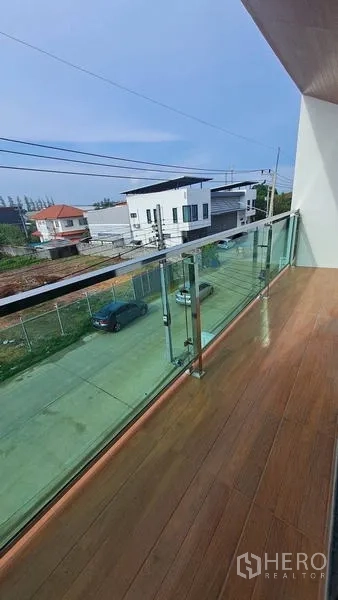 Warehouse for rent in Lam Luk Ka, Pathum Thani - Long balcony with glass railing overlooking a quiet street and low-rise neighborhood.