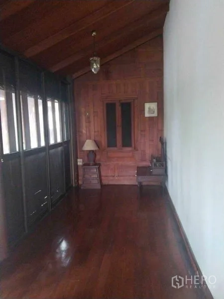 Detached House for rent or sale in Suan Luang, Bangkok - Wood-paneled corridor with high ceiling and natural light from side windows.