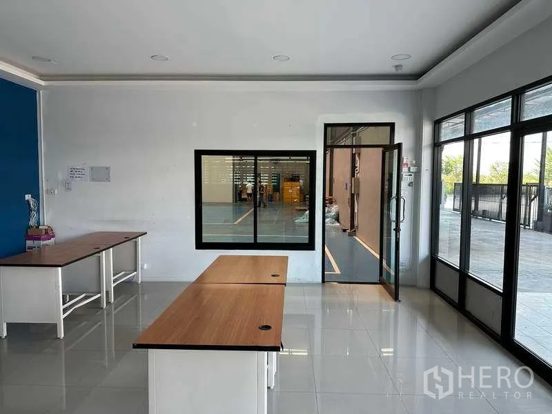 Factory for rent in Samut Prakan - Glass-fronted office area overlooking the production floor.