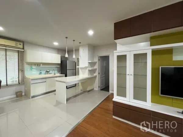 บ้าน ให้เช่าในBang Kapi, Bangkok - ครัวและพื้นที่นั่งเล่นแบบโอเพ่นพร้อมชุดทีวีและไอส์แลนด์