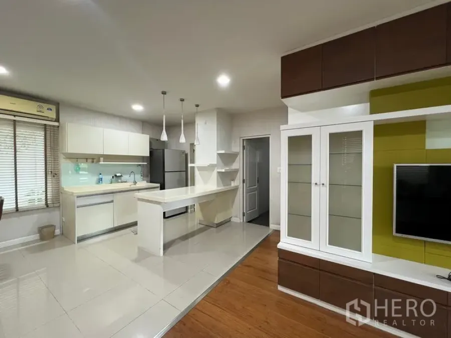 บ้าน ให้เช่าในBang Kapi, Bangkok - ครัวและพื้นที่นั่งเล่นแบบโอเพ่นพร้อมชุดทีวีและไอส์แลนด์