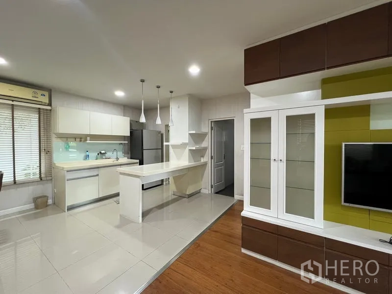 บ้าน ให้เช่าในBang Kapi, Bangkok - ครัวและพื้นที่นั่งเล่นแบบโอเพ่นพร้อมชุดทีวีและไอส์แลนด์