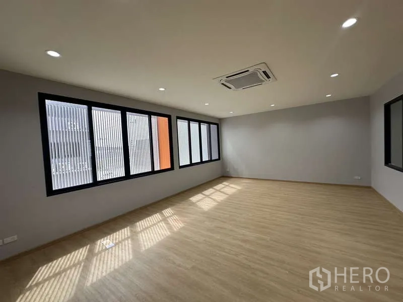 Factory for rent in Lam Luk Ka, Pathum Thani - Large office workspace with long windows, cassette AC and wood-look floor.