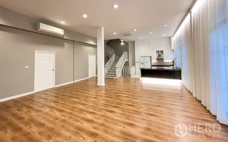 ทาวน์เฮาส์ ให้เช่าในYan Nawa, Bangkok - ห้องนั่งเล่นกว้าง พื้นไม้ ฝ้าเพดานสูง แอร์ และบันไดขึ้นชั้นบน