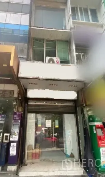 零售空间 出租在Khlong Toei, Bangkok - 街边零售店面外立面，玻璃门面与卷闸门，夹在相邻商铺之间。