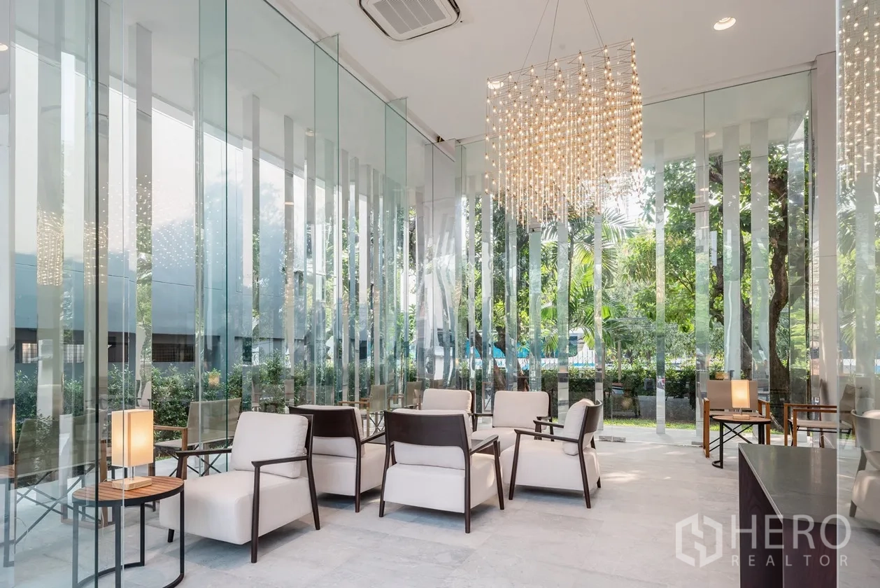 อพาร์ทเมนท์ ให้เช่าในKhlong Toei, Bangkok - ล็อบบี้ผนังกระจกหรู พร้อมโคมระย้าและมุมพักผ่อนมองเห็นสวน