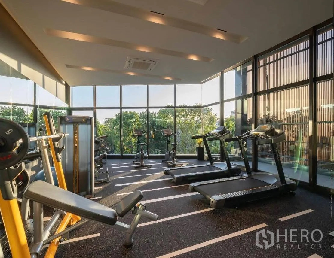 Detached House for rent or sale in Wang Thonglang, Bangkok - Fitness room with treadmills, weights and panoramic glass walls.