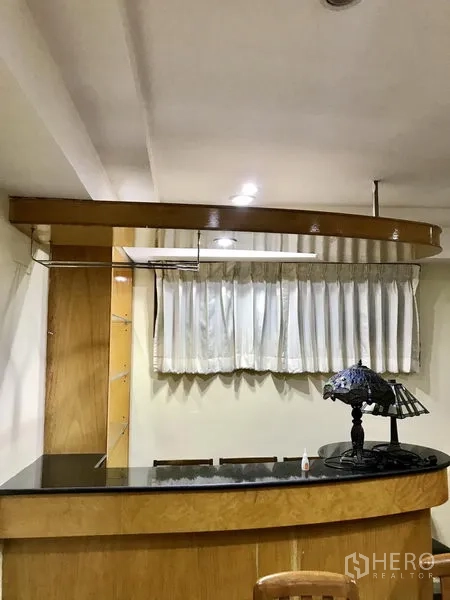 Condominium for rent in Watthana, Bangkok - Built-in home bar with black stone countertop and pendant lighting.