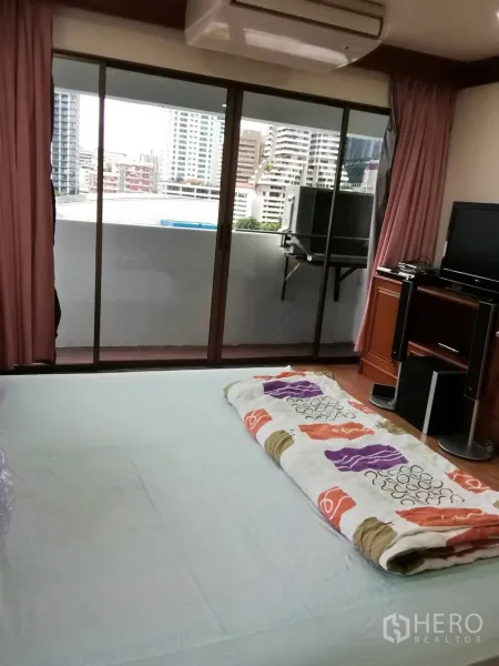 คอนโด ให้เช่าหรือขายในWatthana, Bangkok - ห้องนอนที่มีประตูกระจกบานเลื่อนออกสู่ระเบียงชมวิวเมือง ใกล้ BTS นานา