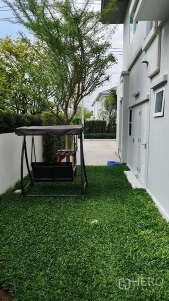 บ้าน ให้เช่าในPrawet, Bangkok - ลานข้างบ้านเป็นสนามหญ้าเขียวพร้อมชิงช้าสวนและรั้วสีขาว