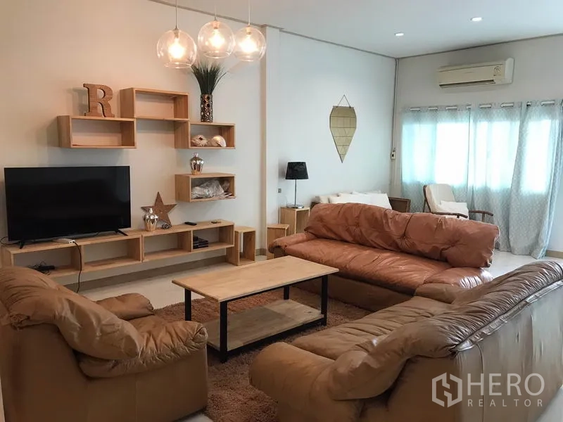 ทาวน์เฮาส์ ให้เช่าหรือขายในPhra Khanong, Bangkok - มุมนั่งเล่นสว่าง โซฟาหนัง ทีวีบิลท์อิน ผ้าม่าน และเครื่องปรับอากาศ