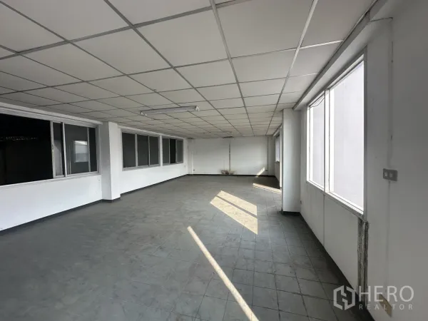 Factory for rent or sale in Khlong Luang, Pathum Thani - Bright office area with grid ceiling, multiple windows and grey tile floor suitable for workstations.