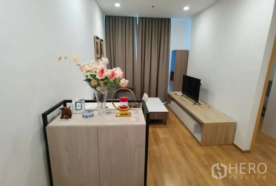 คอนโด ให้เช่าในWatthana, Bangkok - โถงทางเข้าพร้อมชั้นวางทีวี โต๊ะกลาง และของตกแต่ง บนพื้นไม้โทนอุ่น