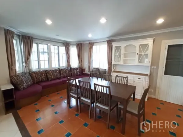 独立式住宅 出租在Mueang Samut Prakan, Samut Prakan - 转角餐区，八人餐桌，飘窗卡座与白色展示柜。