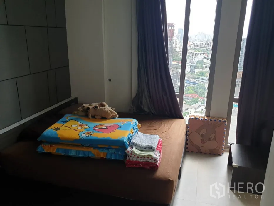 คอนโด ให้เช่าในKhlong Toei, Bangkok - ห้องนอนพร้อมหน้าต่างบานใหญ่ วิวเมือง ผ้าม่านทึบ และเตียงแบบเตี้ย