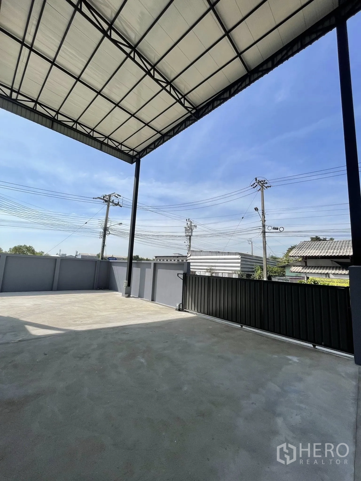 Warehouse for rent in Phra Samut Chedi, Samut Prakan - Gated concrete yard under roof, suitable for truck parking and loading.