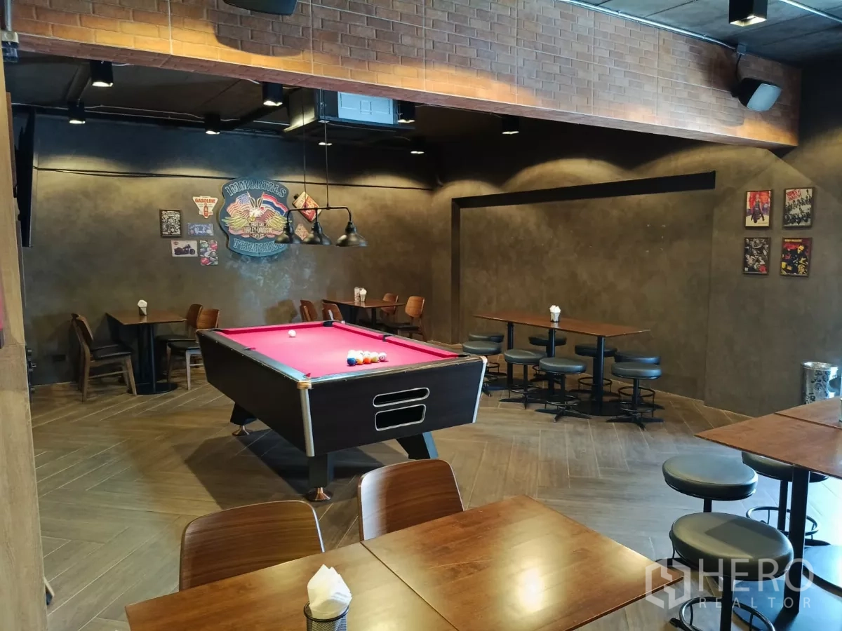 Retail Space for rent - Spacious games area with pink felt pool table and multiple dining tables.