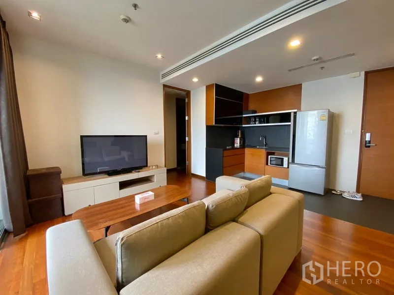 公寓 出租 - 开放式客厅与厨房，配备冰箱与橱柜，沙发组合与温润木地板。