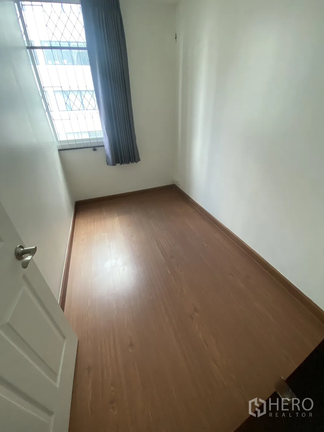 Shophouse for rent in Bang Rak, Bangkok - Narrow room with window, curtain, and security grille.