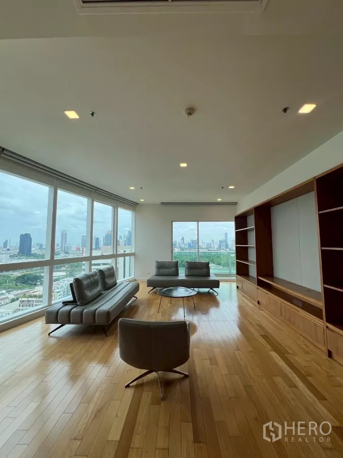 公寓 出租在Khlong Toei, Bangkok - 转角客厅，环幕落地窗、灰色沙发与定制木质电视墙。