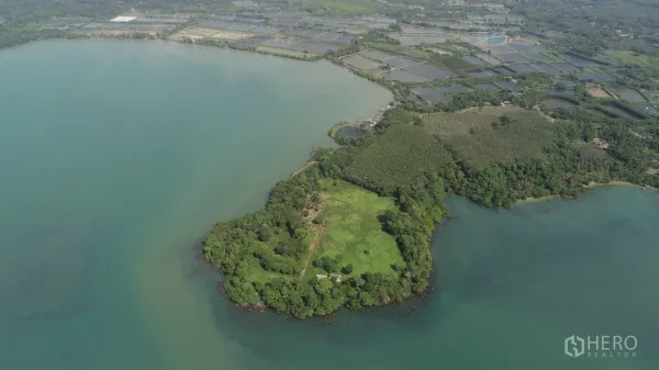 Land for sale in Khlong Toei, Bangkok - High-angle view of coastal land with nearby ponds, farms, and a sheltered bay.