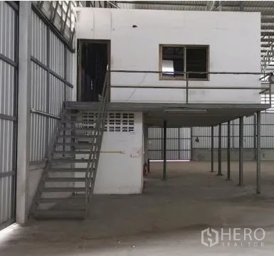 Warehouse for rent in Phra Samut Chedi, Samut Prakan - Close-up of mezzanine office with metal stairs inside the industrial warehouse.