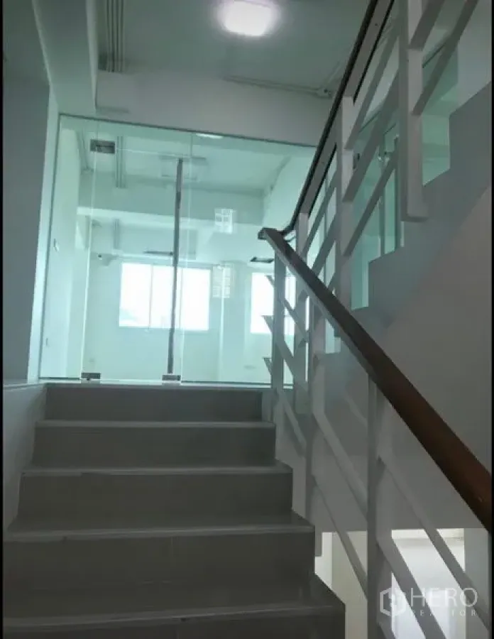 Office Space for rent in Wang Thonglang, Bangkok - Bright stairwell with white railings leading to a glass‑walled office floor in Wang Thonglang, Bangkok.