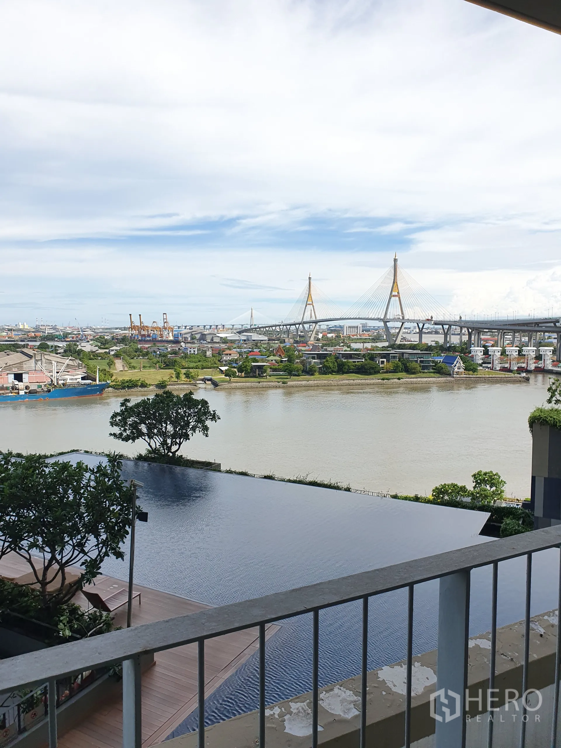 Condominium for rent or sale in Yan Nawa, Bangkok - Balcony view of the infinity pool, Chao Phraya River, and Bhumibol Bridge.