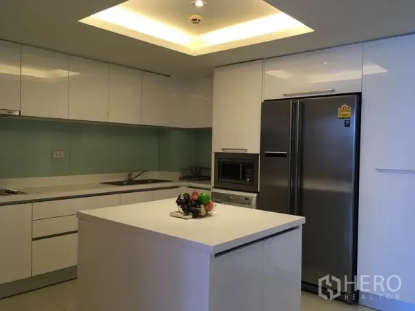 Condominium for rent in Pathum Wan, Bangkok - Modern white kitchen with island, stainless double-door refrigerator and built-in microwave.