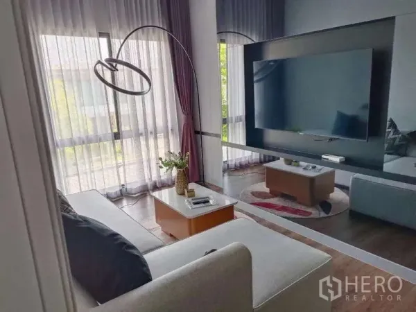 Detached House for rent in Bang Phli, Samut Prakan - Upstairs family lounge with sofa, large wall-mounted TV and tall windows bringing in natural light.