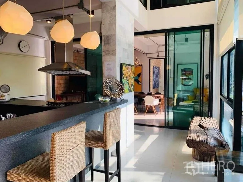 带办公室的家 出售在Wang Thonglang, Bangkok - 现代厨房吧台，吊灯与藤编高脚椅，绿色玻璃推拉门