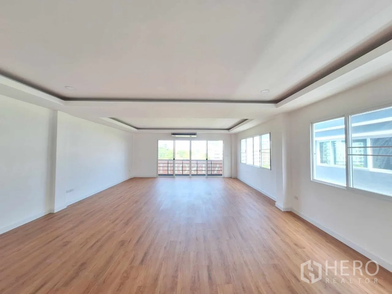 Home Office for sale in Bueng Kum, Bangkok - Long open room with windows on both sides and timber-look floors.