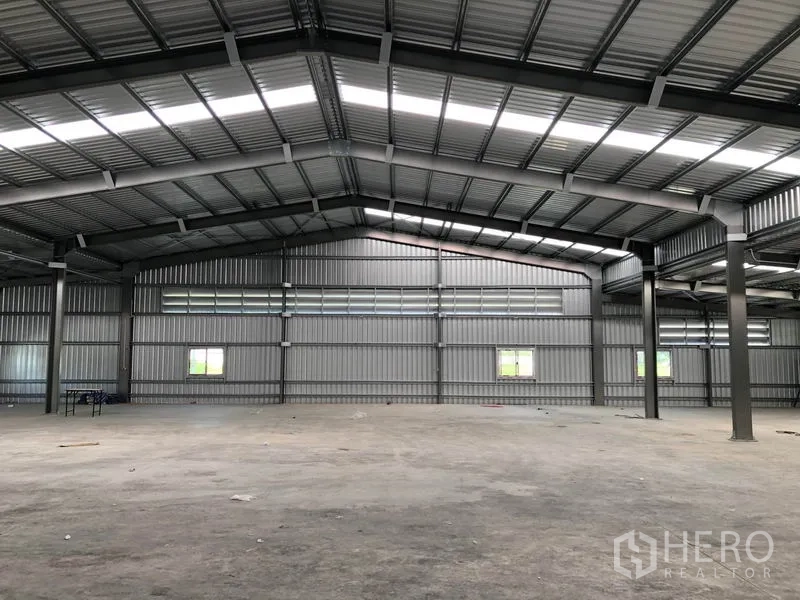 Warehouse for rent in Pak Kret, Nonthaburi - Large warehouse bay with ventilation louvres and multiple windows.