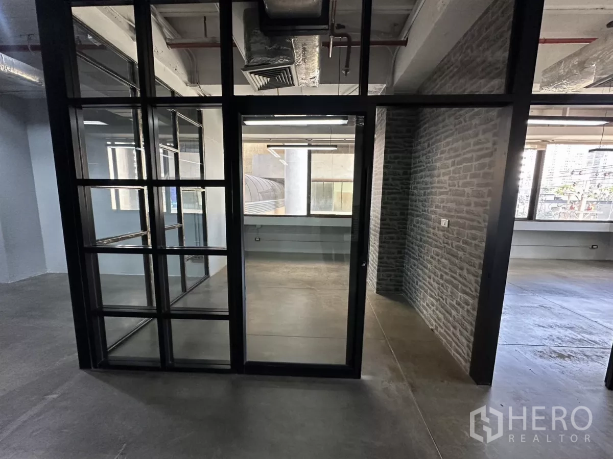 办公空间 出租 - 玻璃门入口，通往工业风封闭办公室。