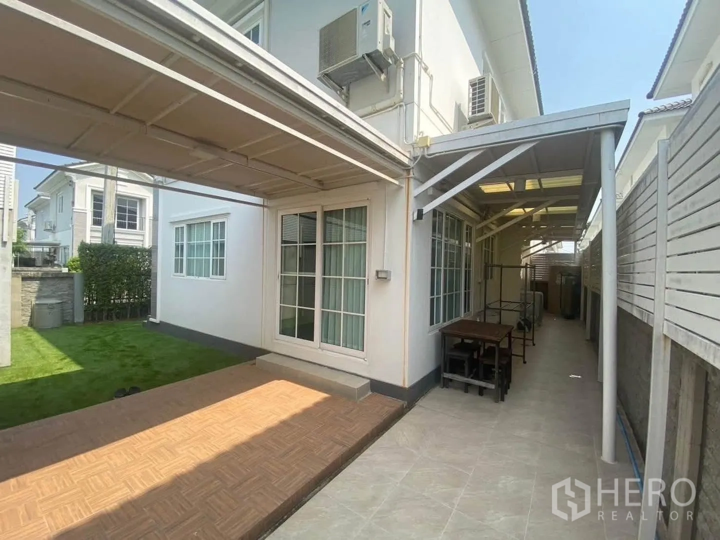 Detached House for rent in Mueang Samut Prakan, Samut Prakan - Covered patio and side yard with sliding glass doors and lawn.