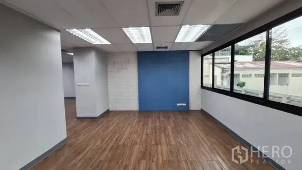 Office Space for rent in Watthana, Bangkok - Open workspace with blue accent wall, LED lighting and long side windows.
