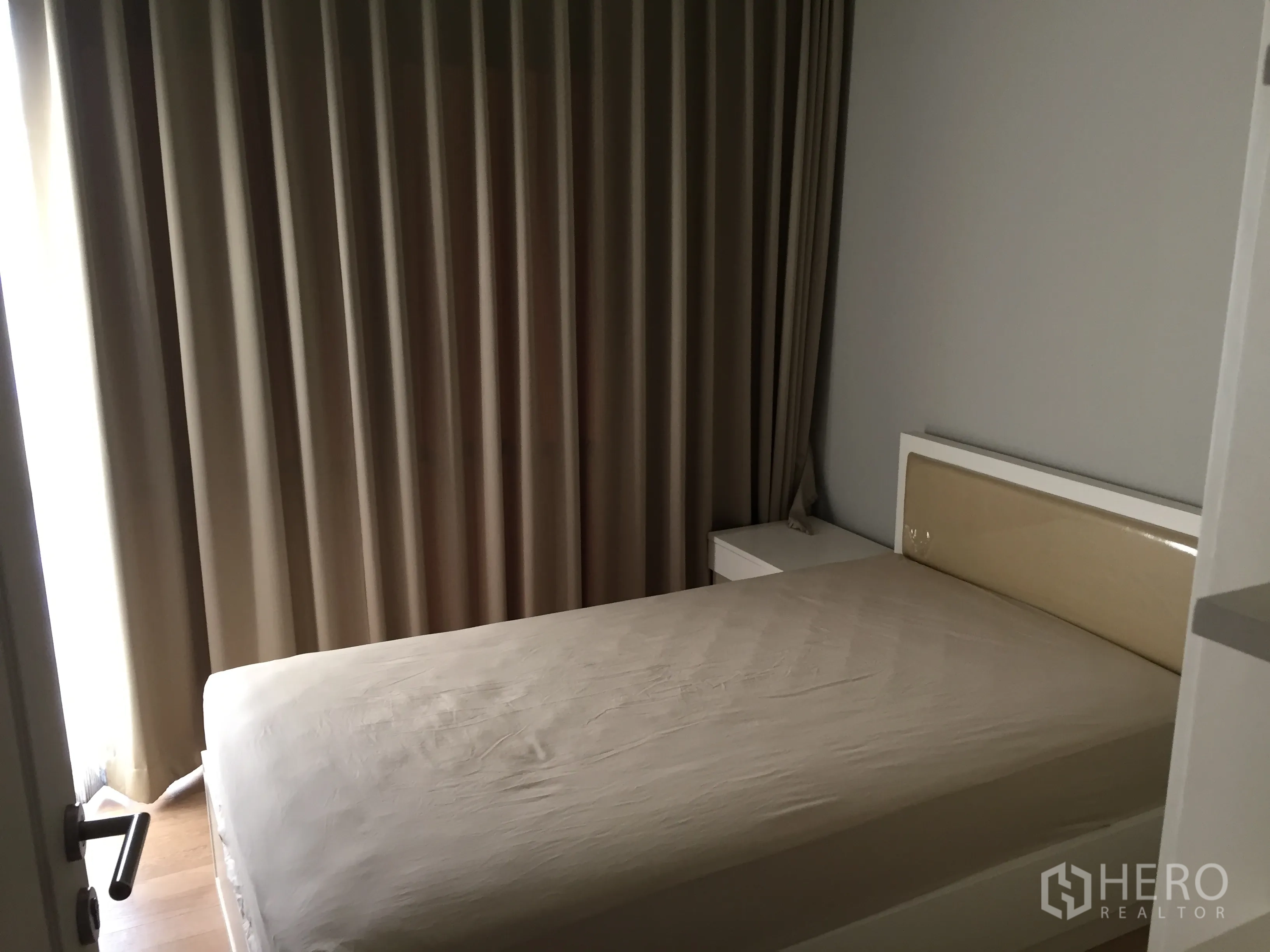 คอนโด ให้เช่าในBangkok - ห้องนอนอบอุ่น เตียงคู่ โต๊ะข้างเตียง และผ้าม่านทึบสูงจรดเพดาน