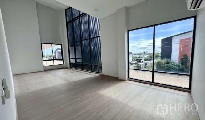 Warehouse for rent in Bang Bo, Samut Prakan - Bright office space with floor-to-ceiling windows, large side window, and an air conditioner.