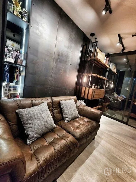 คอนโด ขายในPathum Wan, Bangkok - ห้องนั่งเล่นตกแต่งโทนเข้ม โซฟาหนังและไฟรางส่องสว่าง