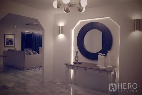 คอนโด ให้เช่าในWatthana, Bangkok - โถงตกแต่งซุ้มเว้าพร้อมไฟซ่อน กระจกกลม และโต๊ะคอนโซล ข้างห้องนั่งเล่น