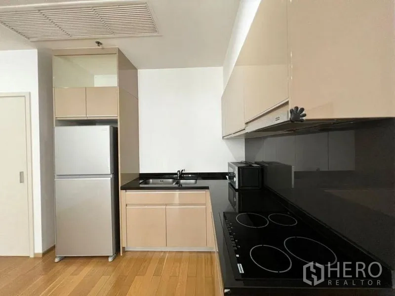 คอนโด ให้เช่าในKhlong Toei, Bangkok - ครัวบิลท์อินสมัยใหม่ หน้าท็อปหินสีดำ เตาไฟฟ้า ไมโครเวฟ และตู้เย็นขนาดใหญ่