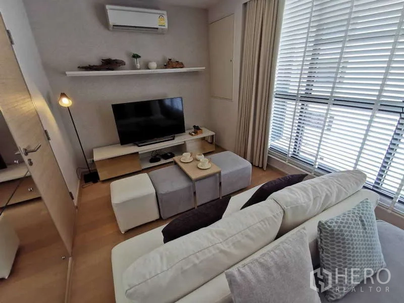 คอนโด ให้เช่าหรือขายในWatthana, Bangkok - ห้องนั่งเล่นสไตล์โมเดิร์น มีทีวี โคมไฟตั้งพื้น ชั้นวางของ และหน้าต่างบานสูงพร้อมมู่ลี่