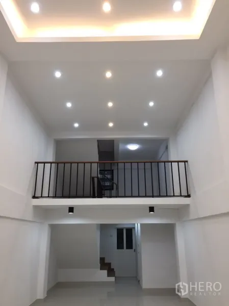 店屋 出租在Suan Luang, Bangkok - 一层明亮通高空间，嵌灯吊顶与夹层栏杆，适合展厅或办公室。