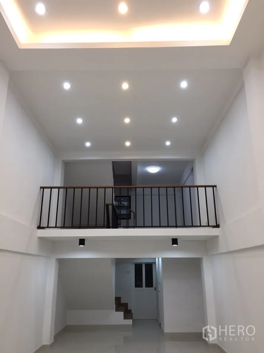 店屋 出租在Suan Luang, Bangkok - 一层明亮通高空间，嵌灯吊顶与夹层栏杆，适合展厅或办公室。