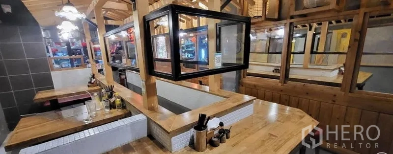 店屋 出租在Khlong Toei, Bangkok - 内置就餐吧台与卡座，木质饰面与吊灯。