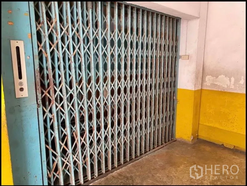 工厂 出租在Chom Thong, Bangkok - 旧式货运电梯，折叠金属闸门。