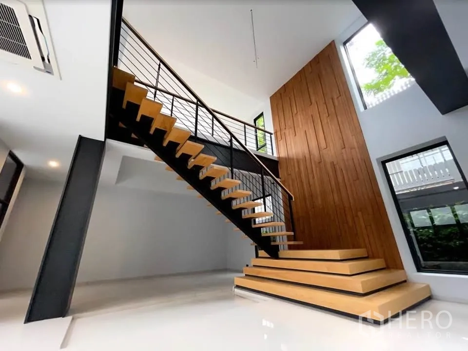 Detached House for sale in Watthana, Bangkok - Double-height foyer with a floating wooden staircase and large windows.