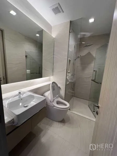 คอนโด ให้เช่าในRatchathewi, Bangkok - ห้องน้ำสมัยใหม่พร้อมฉากกั้นอาบน้ำกระจก กระจกบานใหญ่ และสุขภัณฑ์