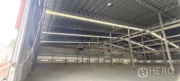货栈 出租在Nikhom Phatthana, Rayong - 仓库内部，高钢结构屋顶与天窗灯带，开阔的混凝土地面。