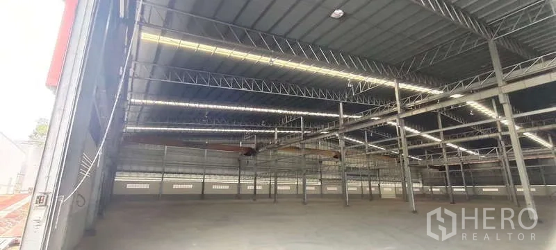货栈 出租在Nikhom Phatthana, Rayong - 仓库内部，高钢结构屋顶与天窗灯带，开阔的混凝土地面。